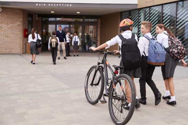 Children with bikes walking into school