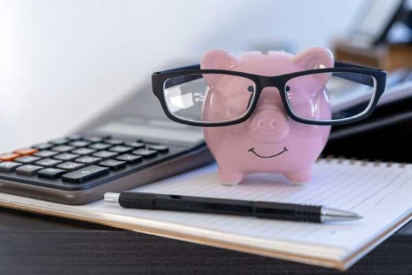 pink smiling piggy bank with glasses and calculator