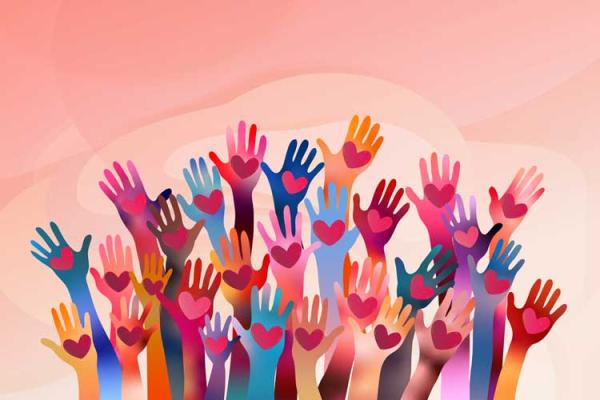 Different coloured hands in the air with hearts in palms