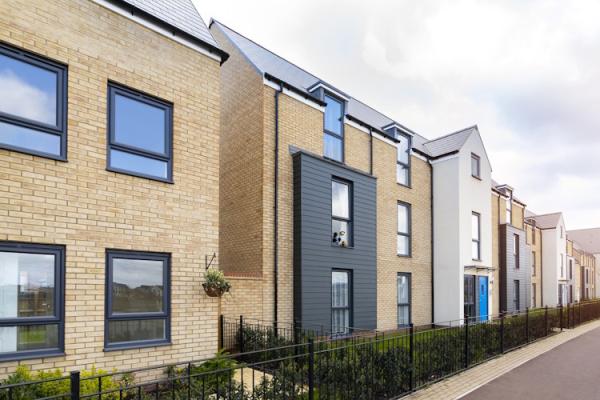 Several new build, three-storey terraced houses with neat gardens.
