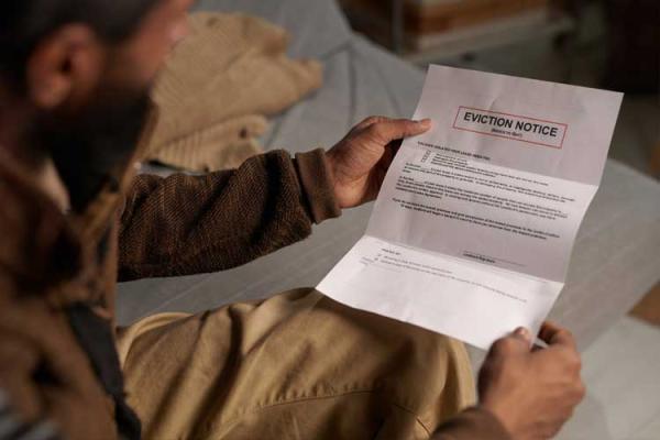 Man sitting down holding an eviction notice letter