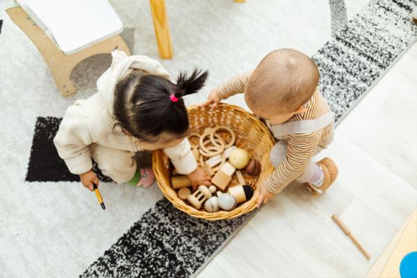 Ariel view of toddlers around a weaved basket with toys