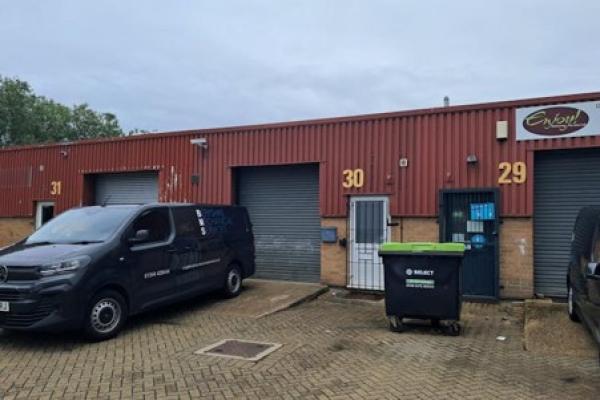 Outside of commercial unit with black van parked outside a garage with the number 30