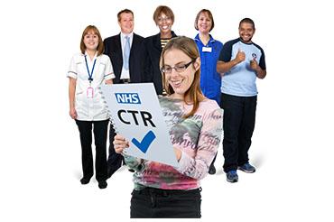 Group of professionals smiling with a woman holding an NHS CTR document in the foreground.