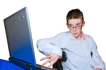 A young person with glasses looking at a laptop on a blue table.